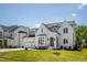 Charming two-story home featuring a white brick facade, black roof, arched entryway, and an attached two-car garage at 928 Lily Claire Ln, Fuquay Varina, NC 27526