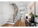 Welcoming home foyer with hardwood flooring, a staircase, decorative console table, and plenty of natural light at 928 Lily Claire Ln, Fuquay Varina, NC 27526