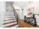 Bright home foyer featuring hardwood flooring, an elegant staircase, and a decorative console table with stylish decor at 928 Lily Claire Ln, Fuquay Varina, NC 27526