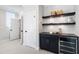 Hallway featuring a modern dry bar with dark cabinets and floating shelves at 928 Lily Claire Ln, Fuquay Varina, NC 27526