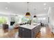 Open-concept kitchen, living, and dining area with hardwood floors and natural light at 928 Lily Claire Ln, Fuquay Varina, NC 27526