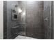 Modern shower featuring dark tile, pebble floor, glass door and built-in niche at 928 Lily Claire Ln, Fuquay Varina, NC 27526