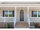 Front porch with classic design elements, including white columns and a gray front door at 9391 Turkey Way, Middlesex, NC 27557