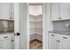 Open pantry with white shelves and cabinets features granite counters and wood floors at 9391 Turkey Way, Middlesex, NC 27557
