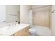 Bright bathroom featuring a shower-over-tub, neutral tile, light wood vanity, and chrome fixtures at 101 Becklow Ridge Lane Ln, Holly Springs, NC 27540