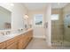 Bathroom featuring a double vanity, a frameless glass shower, and bright recessed lighting at 101 Becklow Ridge Lane Ln, Holly Springs, NC 27540