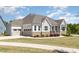 Attractive home featuring a three-car garage and appealing exterior design with stone accents at 101 Becklow Ridge Lane Ln, Holly Springs, NC 27540