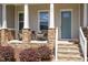 Inviting front porch with stone accents, comfortable seating, and a decorative front door at 101 Becklow Ridge Lane Ln, Holly Springs, NC 27540