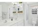 Bright bathroom featuring double sinks, a window, and a shower-tub with a white and blue shower curtain at 101 Silk Leaf, Cary, NC 27518