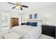 Bright bedroom with a ceiling fan, soft white walls, and contrasting dark blue accent pillows at 101 Silk Leaf, Cary, NC 27518