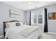 Cozy bedroom featuring a queen bed, soft blue walls, and bright natural light from the window at 101 Silk Leaf, Cary, NC 27518
