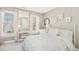 Light-filled bedroom with neutral walls and accents, featuring a makeup vanity and windows at 101 Silk Leaf, Cary, NC 27518