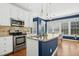 Bright kitchen featuring stainless steel appliances, granite counters, and an island with a sink at 101 Silk Leaf, Cary, NC 27518