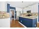 Modern kitchen with white cabinets, granite countertops, stainless steel appliances, and blue island at 101 Silk Leaf, Cary, NC 27518