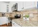 Close-up of the kitchen with granite countertops, white cabinets, and stainless steel appliances at 101 Silk Leaf, Cary, NC 27518