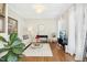 Cozy living room with hardwood floors, a sofa, and a large green plant at 101 Silk Leaf, Cary, NC 27518