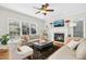 Bright and airy living room with hardwood floors, fireplace, neutral furniture, and modern ceiling fan at 101 Silk Leaf, Cary, NC 27518