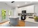 Well-lit kitchen with island, stainless steel appliances, and hardwood floors at 1029 Frank Page Dr, Cary, NC 27519