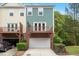 Rear townhouse exterior view with private deck above garage, and lush green landscaping at 1029 Frank Page Dr, Cary, NC 27519