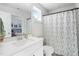 Bright bathroom with a decorative shower curtain, large mirror and a single sink vanity at 1036 S Fieldhaven Dr, Fuquay Varina, NC 27526