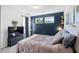 Cozy bedroom with a padded headboard, accent wall, and windows with natural views at 1036 S Fieldhaven Dr, Fuquay Varina, NC 27526