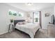 Well lit bedroom with large windows, neutral walls, and patterned bedding at 1036 S Fieldhaven Dr, Fuquay Varina, NC 27526