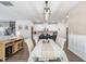 Open-concept dining room featuring updated lighting fixtures, stylish decor, and wood flooring at 1036 S Fieldhaven Dr, Fuquay Varina, NC 27526