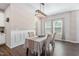 Dining room with an elegant light fixture, wainscoting, and large windows at 1036 S Fieldhaven Dr, Fuquay Varina, NC 27526