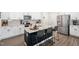 Modern kitchen with white cabinets, granite countertops, a center island, and stainless steel appliances at 1036 S Fieldhaven Dr, Fuquay Varina, NC 27526