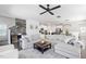 Living room showcases a large gray sectional, ceiling fan, and opens to the modern white kitchen at 1036 S Fieldhaven Dr, Fuquay Varina, NC 27526