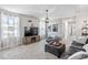 Spacious living room featuring a large TV, cozy seating, and soft natural light from the windows at 1036 S Fieldhaven Dr, Fuquay Varina, NC 27526