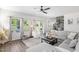 Bright living room features hardwood floors, a gray sectional, and views to the backyard at 1036 S Fieldhaven Dr, Fuquay Varina, NC 27526
