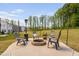 Outdoor patio area with a stone fire pit, comfortable seating, and a backyard view at 1036 S Fieldhaven Dr, Fuquay Varina, NC 27526