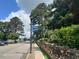 Street view showcasing a paved road, rock wall, and verdant trees, capturing a scenic community at 1036 S Fieldhaven Dr, Fuquay Varina, NC 27526