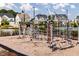 Gathering-friendly community playground features various play structures with neighborhood homes and a pool in the background at 104 Sodalite Ln, Holly Springs, NC 27540