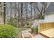 Backyard landscaped with stone path, mature trees, and white railing steps at 108 Monarch Way, Cary, NC 27518
