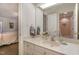 Bright bathroom with white vanity, sink, and mirror, showing doorway to bedroom and an adjacent bathroom at 108 Monarch Way, Cary, NC 27518