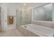 Modern bathroom with a soaking tub, glass-enclosed shower, and marble tile surround at 108 Monarch Way, Cary, NC 27518