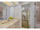 Bright bathroom featuring a sink, vanity and mirror with a peek into the closet and bathtub at 108 Monarch Way, Cary, NC 27518