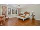 Bright bedroom with a king bed, hardwood floors, and natural light from large windows at 108 Monarch Way, Cary, NC 27518