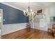 Open dining space with blue walls, a chandelier, and stairs leading to the upper level at 108 Monarch Way, Cary, NC 27518