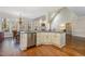 Open kitchen design with stainless steel appliances, island with seating, and hardwood floors at 108 Monarch Way, Cary, NC 27518