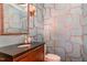 Stylish powder room featuring unique wallpaper, dark granite countertop, and modern fixtures at 108 Monarch Way, Cary, NC 27518