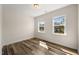 Bedroom with hardwood floors and two windows overlooking the neighborhood at 1120 Copper Beech Ln, Wake Forest, NC 27587