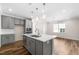 Well-lit kitchen with gray cabinets, stainless steel appliances, a center island, and hardwood floors at 1120 Copper Beech Ln, Wake Forest, NC 27587