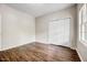Neutral bedroom featuring wood-look flooring, closet, and natural light from the window at 1123 Claret Ln, Morrisville, NC 27560