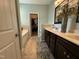 Bathroom featuring dual sinks, dark cabinetry, tub, and a door to the walk in closet at 116 Polenta Fields Dr, Smithfield, NC 27577