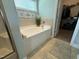 Bright bathroom featuring a soaking tub with decorative accents and walk-in closet at 116 Polenta Fields Dr, Smithfield, NC 27577