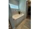 Inviting bathtub with tiled surround and a window for natural light, adjacent to a walk-in closet at 116 Polenta Fields Dr, Smithfield, NC 27577
