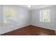 Bright bedroom with hardwood floors and lots of natural light from two windows with white trim at 116 W Mciver St, Zebulon, NC 27597